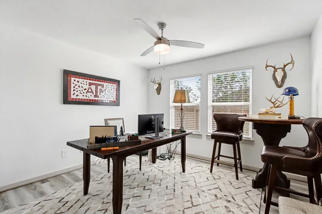 a view of a workspace with furniture and a window