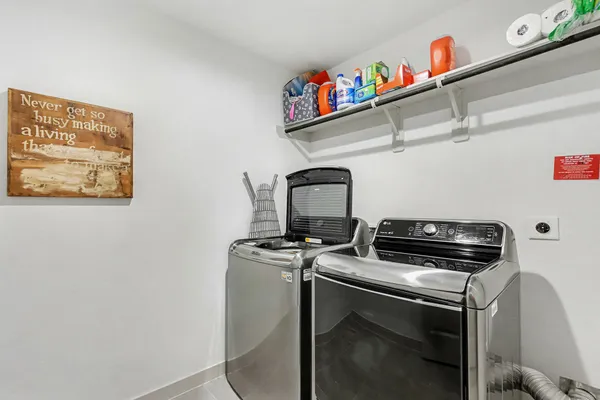 a utility room with dryer washer and on wooden floor