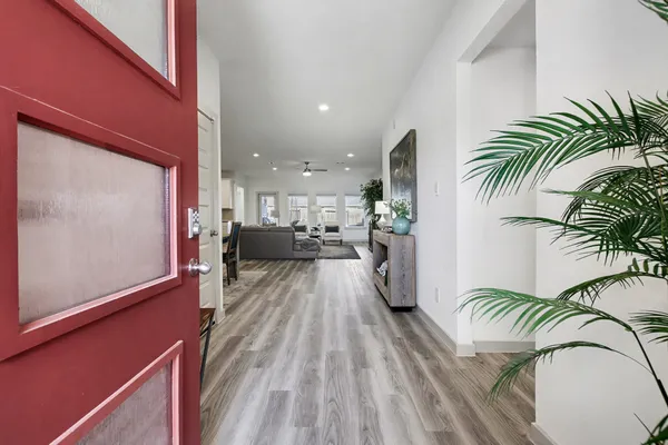 a view of a hallway with furniture and floor to ceiling window