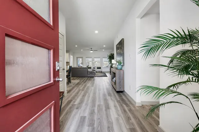 a view of a hallway with furniture and floor to ceiling window