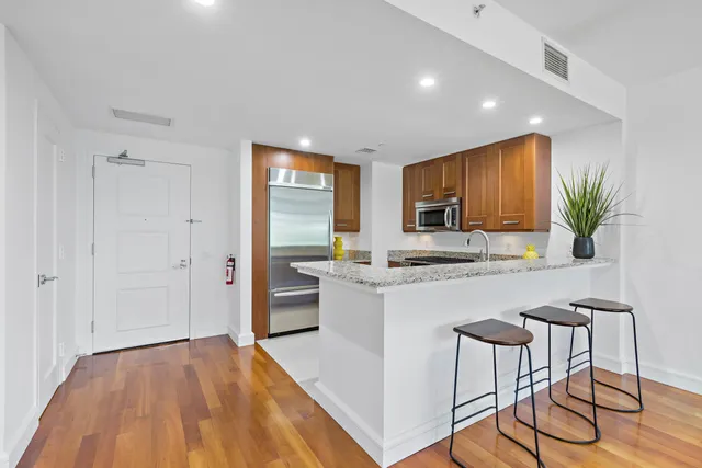 a kitchen with stainless steel appliances granite countertop a refrigerator and a stove top oven