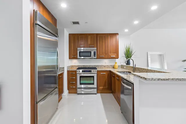 a kitchen with stainless steel appliances granite countertop a stove top oven a sink and dishwasher
