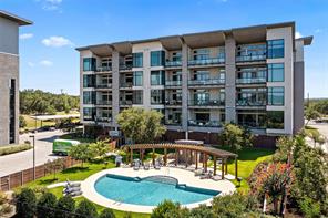 5921 Hiline Road, Unit 1203 Austin, TX 78734 - Photo 29 of 34 A sparkling community swimming pool sits adjacent to this modern multi-story residential building.