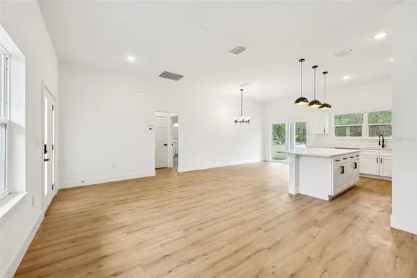 a view of a room with wooden floor and ceiling fan