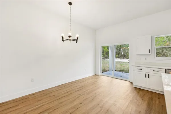 a kitchen with stainless steel appliances granite countertop a sink a stove a refrigerator cabinets and wooden floor