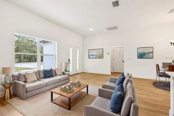 a large kitchen with granite countertop a stove top oven a sink dishwasher with a dining table and chairs with wooden floor