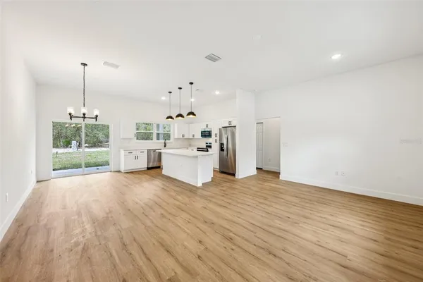 a very nice looking room with kitchen island stainless steel appliances and furniture