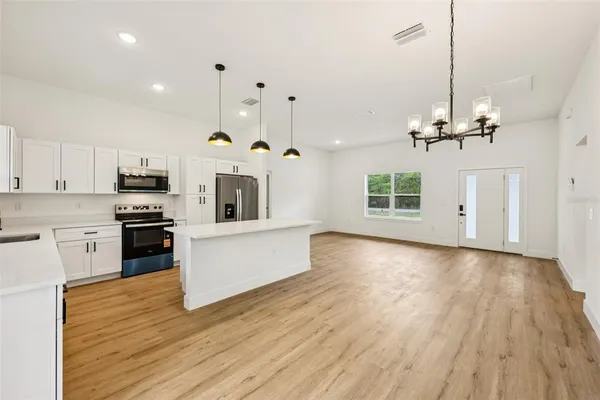 a large white kitchen with a sink and dishwasher