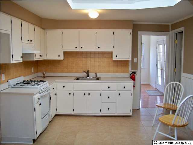112 North Cooks Bridge Road Jackson, NJ 08527 - Photo 3 of 3 a kitchen with granite countertop a white stove top oven a sink a window and white cabinets