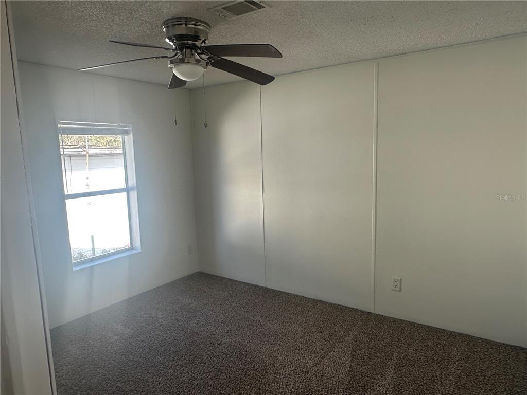 447 Tindel Camp Road Lake Wales, FL 33898 - Photo 9 of 15 an empty room with windows and fan