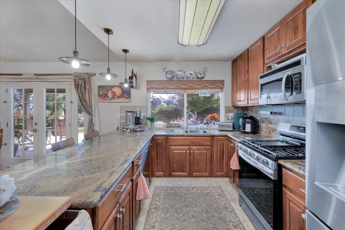 16397 Road 37 Madera, CA 93636 - Photo 18 of 74 Kitchen overlooks the backyard, has granite counters, built in microwave, super efficient kitchen.