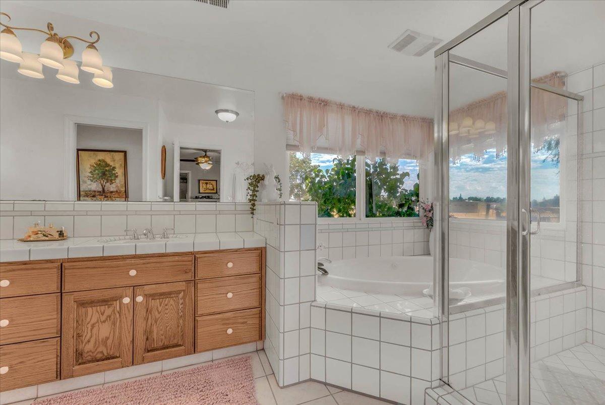 16397 Road 37 Madera, CA 93636 - Photo 27 of 74 a bathroom with a granite countertop sink a mirror and shower