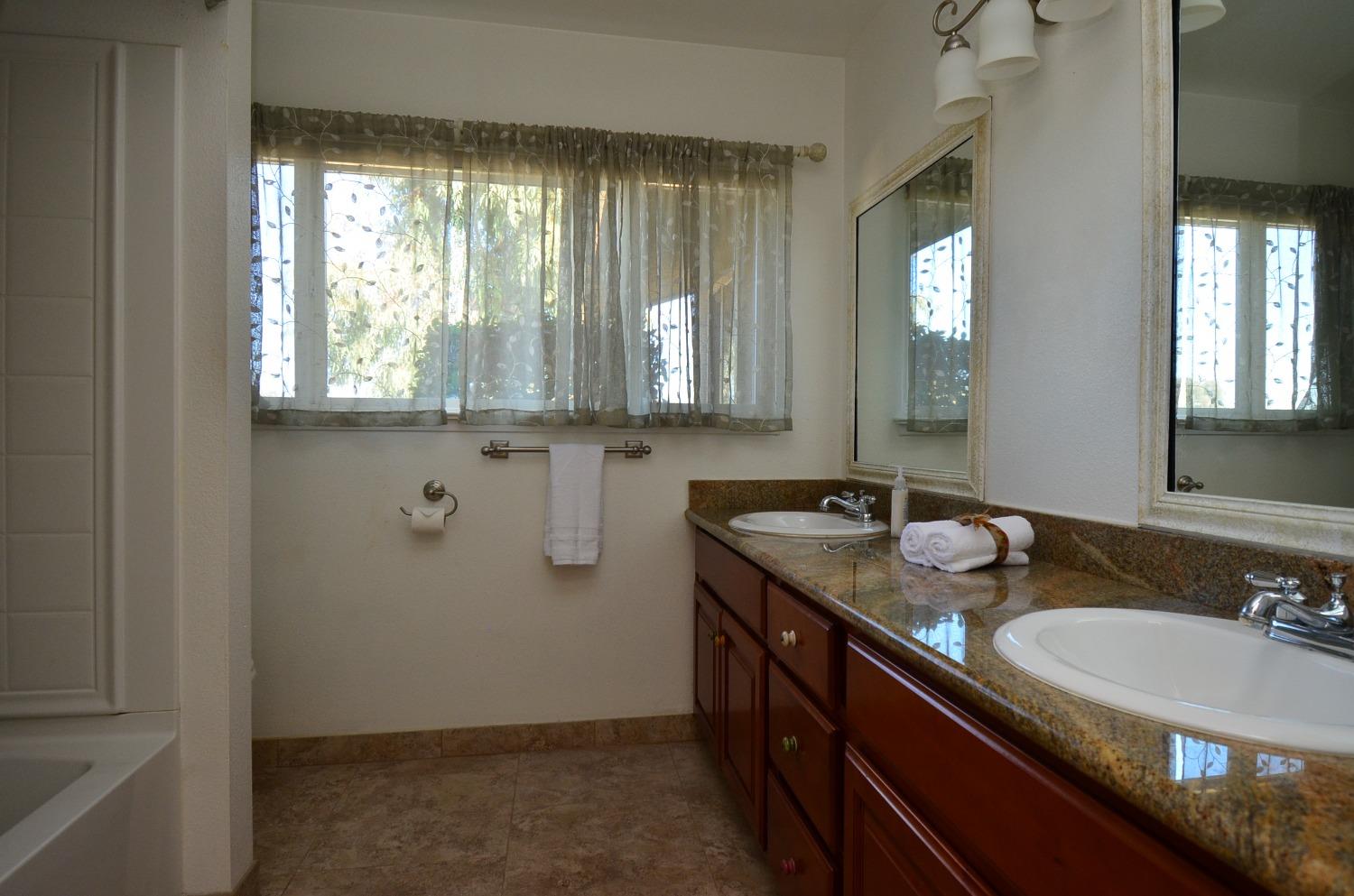 16397 Road 37 Madera, CA 93636 - Photo 9 of 74 a bathroom with a granite countertop sink a large mirror a and window