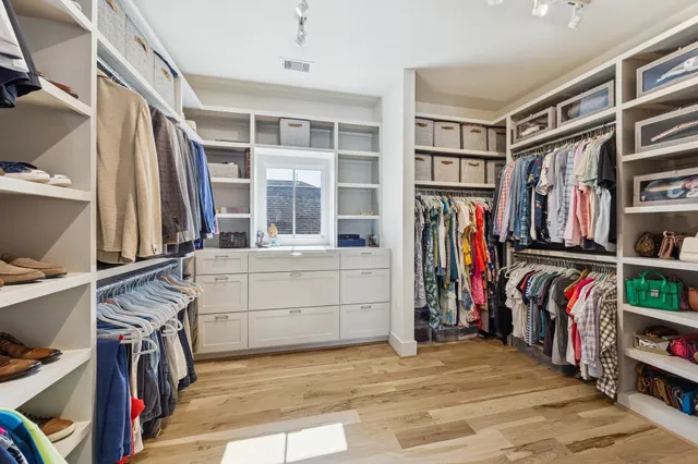 a view of walk in closet with clothes and shoes