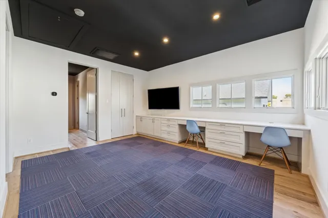 a living room with a flat screen tv and kitchen view