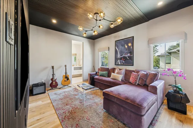 a living room with furniture a chandelier and a large window