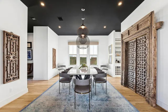a dining room with furniture a large window and chandelier