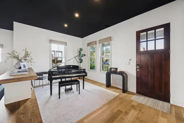 a living room with furniture a piano and a window