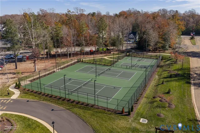 a view of a tennis ground with large trees