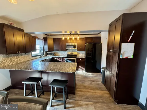a kitchen with granite countertop counter space a sink appliances and cabinets