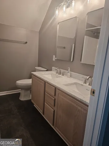 a bathroom with a sink a toilet and mirror