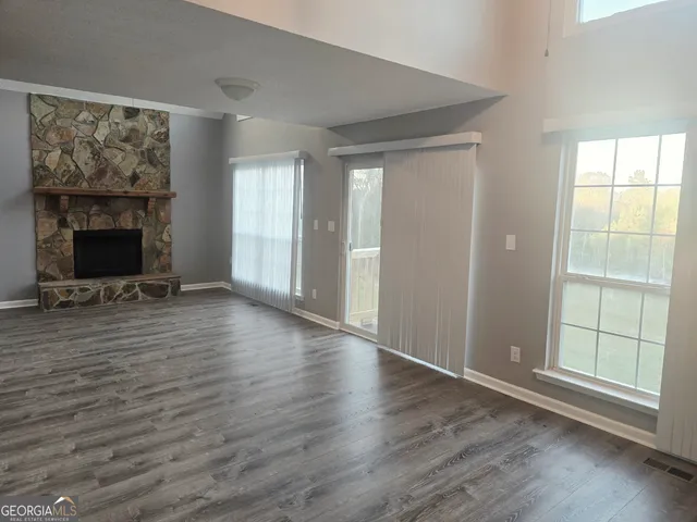 a view of a livingroom with wooden floor and a fireplace