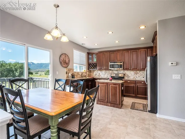 a view of a dining room with furniture a chandelier and wooden floor