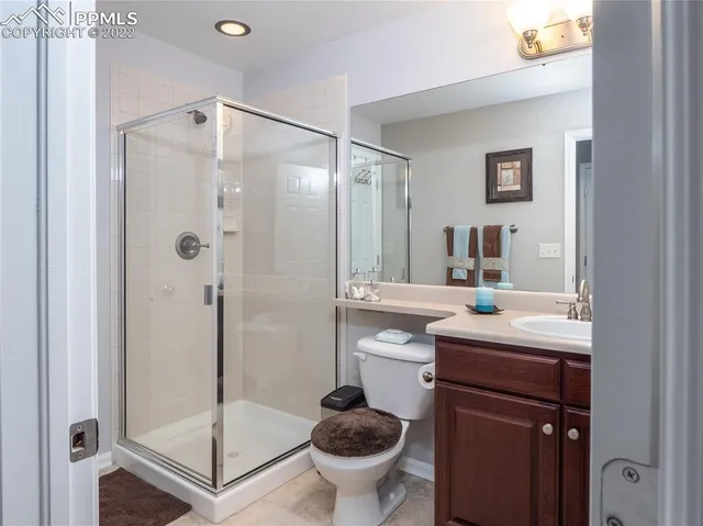 a bathroom with a granite countertop sink a toilet and shower