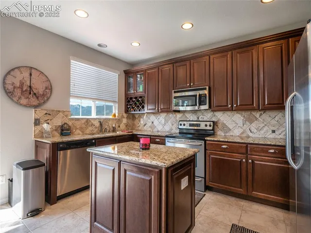 a kitchen with stainless steel appliances granite countertop a stove a sink dishwasher and a microwave oven with cabinets