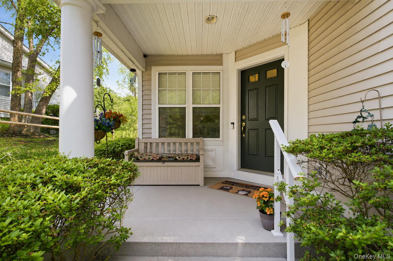 64 Roma Orchard Road Peekskill, NY 10566 - Photo 3 of 40 Covered front porch featuring a dark paneled entry door, light-colored siding, and white trim