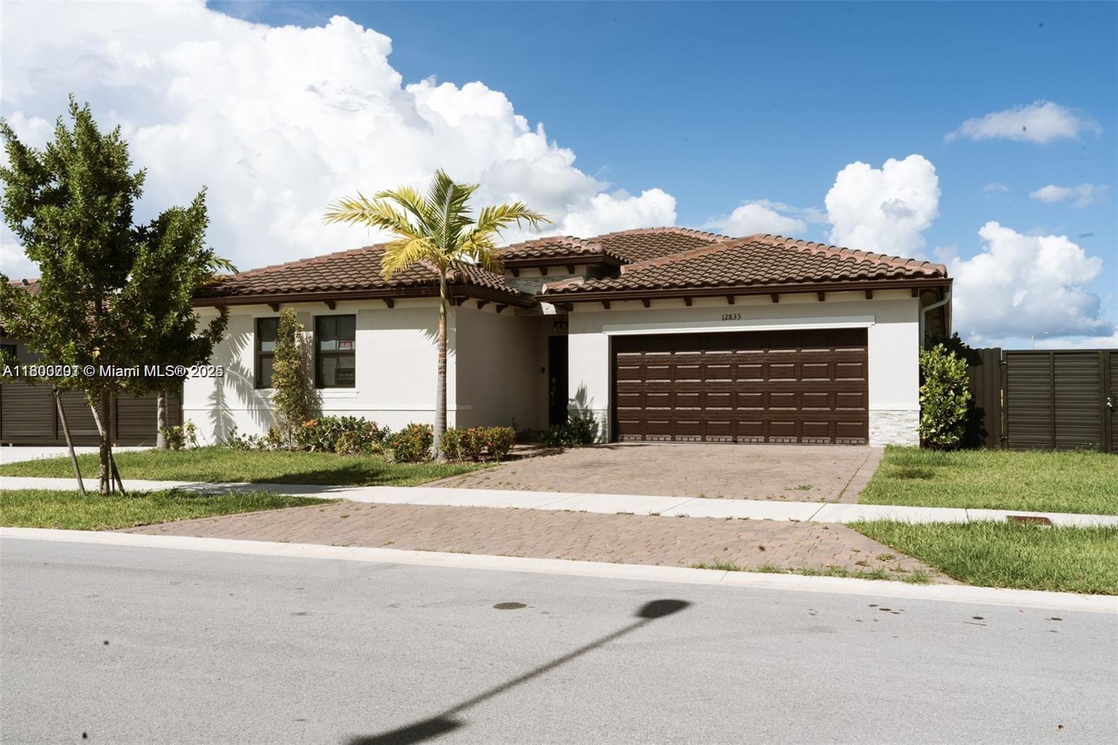a front view of a house with a yard and a garage