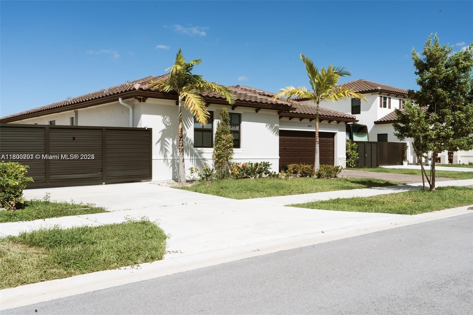 12833 Southwest 226th Street Miami, FL 33170 - Photo 2 of 13 a front view of a house with a yard and garage