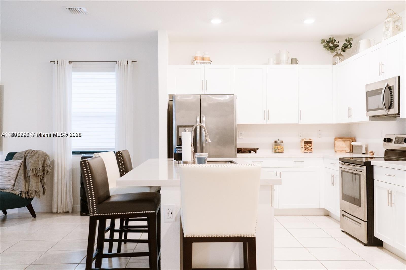 12833 Southwest 226th Street Miami, FL 33170 - Photo 8 of 13 a kitchen with stainless steel appliances kitchen island granite countertop a sink and cabinets