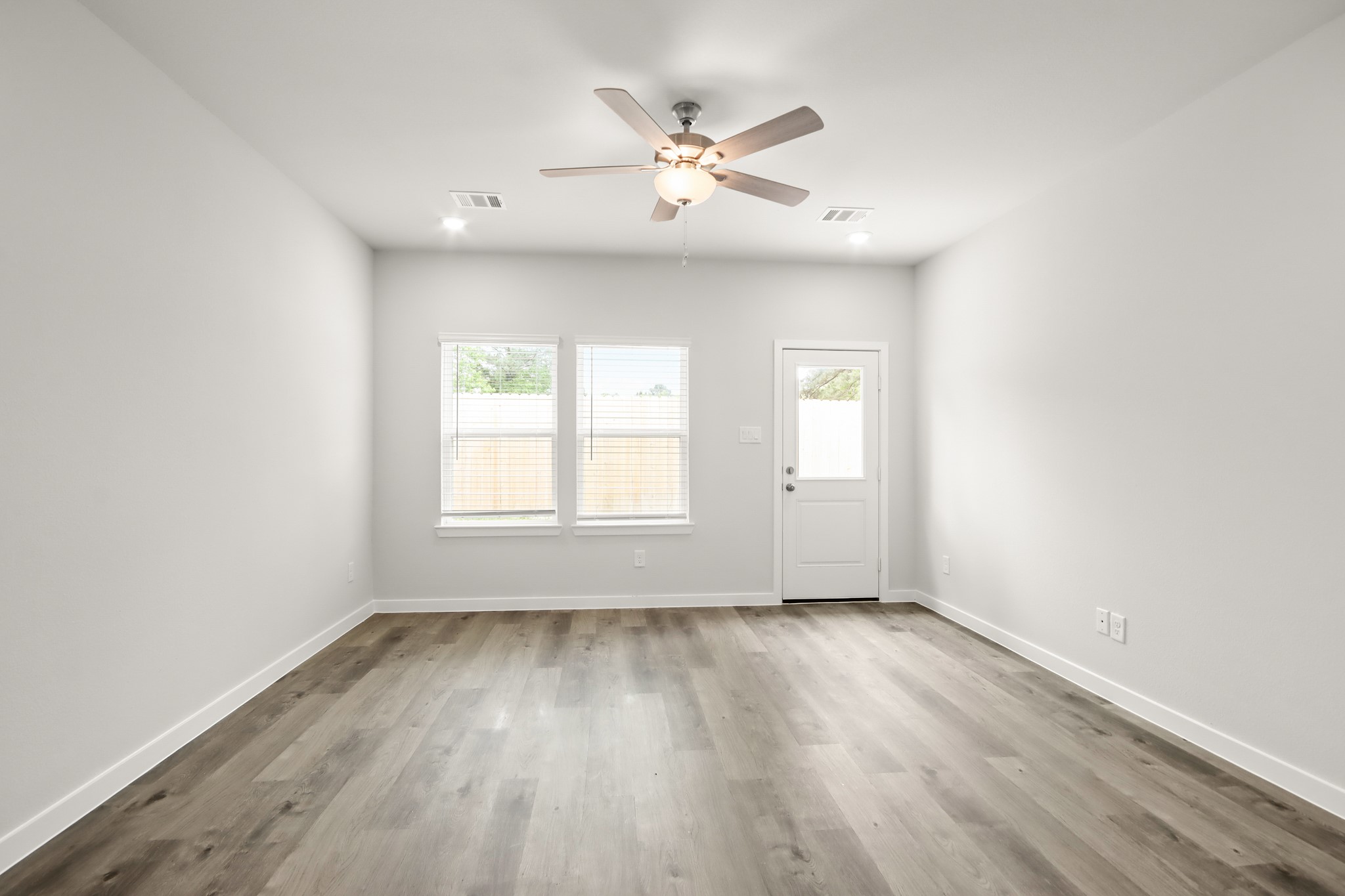 225 Spring Drive Hockley, TX 77447 - Photo 4 of 24 an empty room with wooden floor and windows