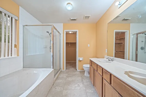 a spacious bathroom with a tub sink and mirror