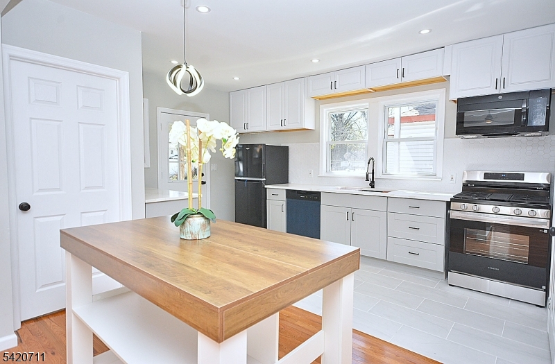 1324 George Street Plainfield, NJ 07062 - Photo 12 of 24 a kitchen with stainless steel appliances granite countertop a sink a stove a dining table and chairs