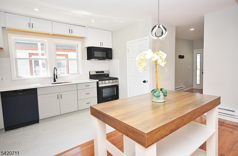 1324 George Street Plainfield, NJ 07062 - Photo 7 of 24 a kitchen with a table chairs stove and microwave