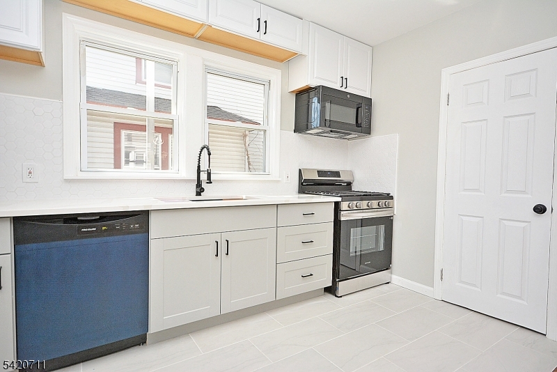 1324 George Street Plainfield, NJ 07062 - Photo 8 of 24 a kitchen with stainless steel appliances granite countertop a stove a sink and a microwave