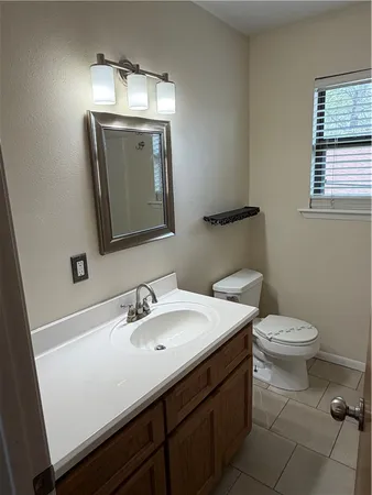 a bathroom with a toilet sink and mirror