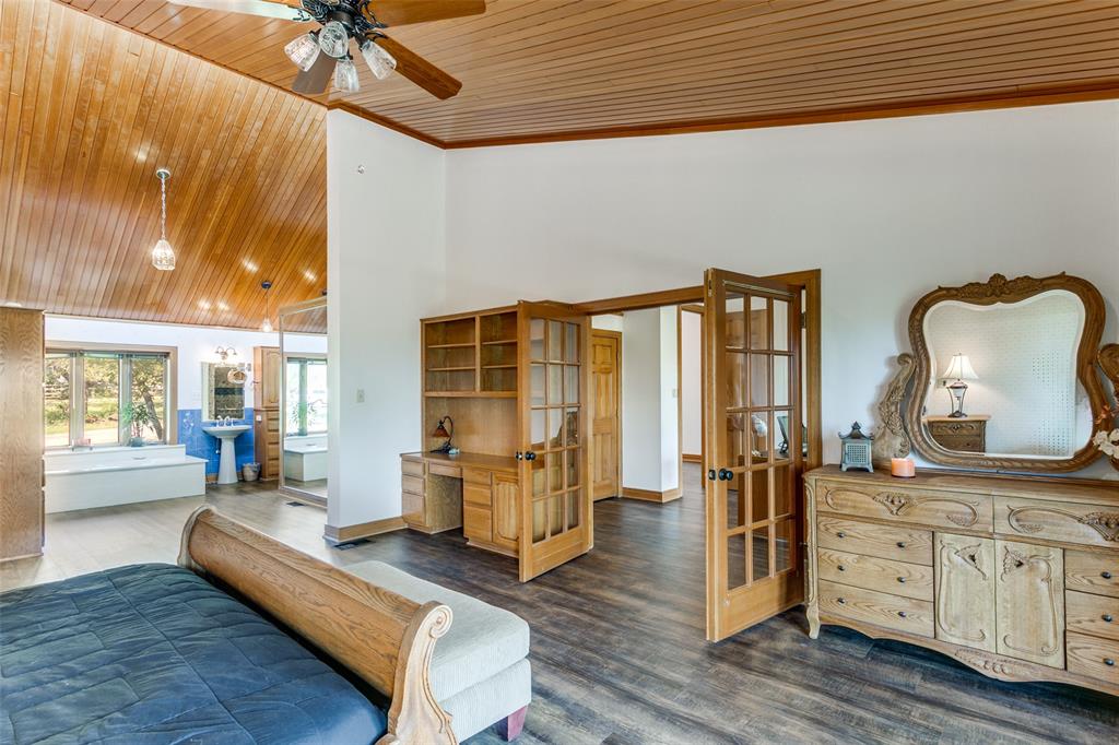 1557 Latigo Hills Road Bartonville, TX 75022 - Photo 17 of 40 Bedroom featuring french doors, a vaulted wood ceiling, dark wood-style flooring, crown molding, and a ceiling fan
