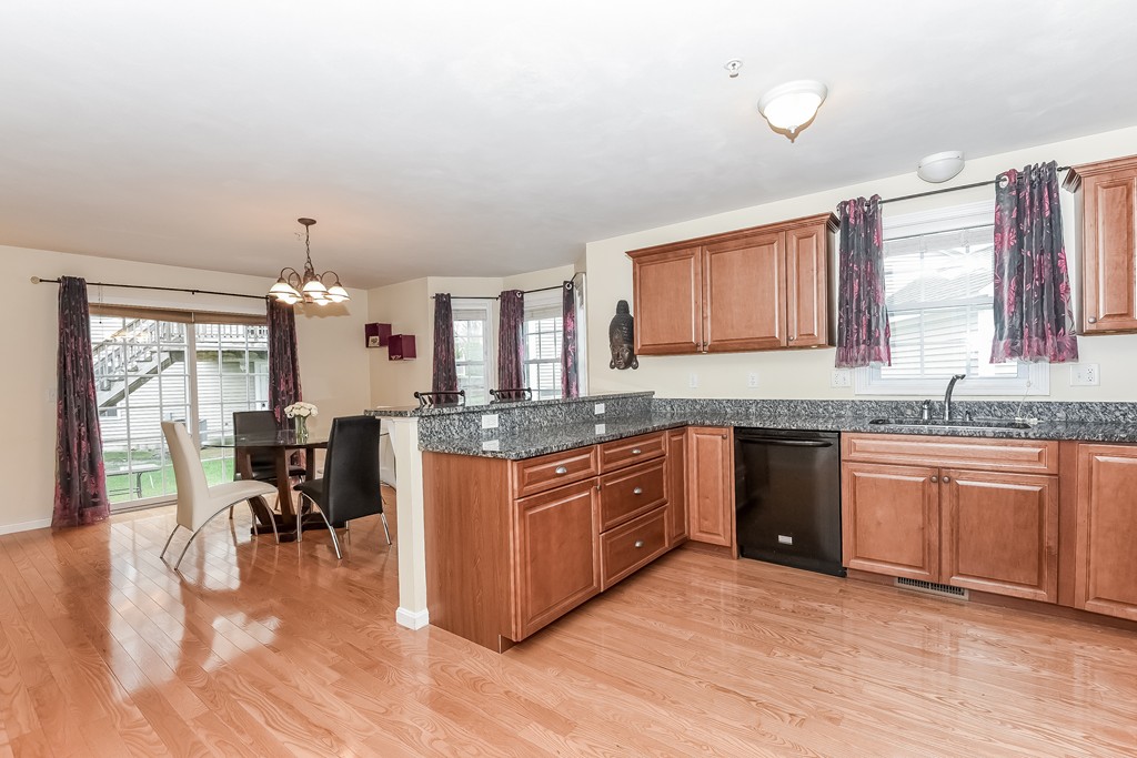 615 Nashua Road, Unit 9 Dracut, MA 01826 - Photo 2 of 30 a kitchen with stainless steel appliances granite countertop a kitchen island hardwood floor sink stove dining table and chairs