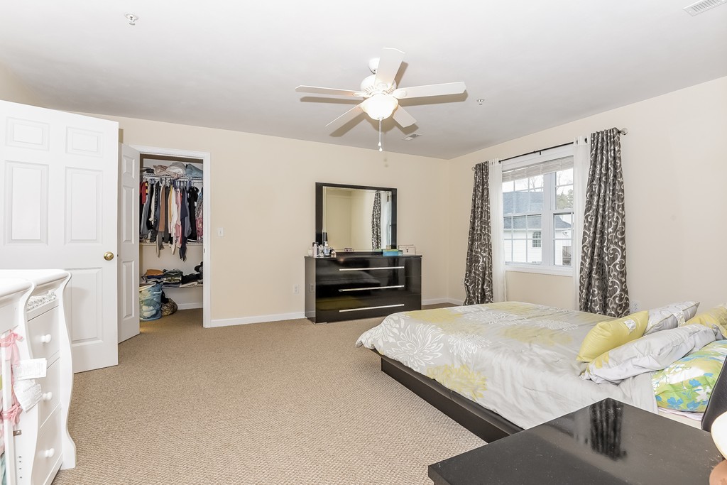 615 Nashua Road, Unit 9 Dracut, MA 01826 - Photo 23 of 30 a bedroom with a bed and a chandelier