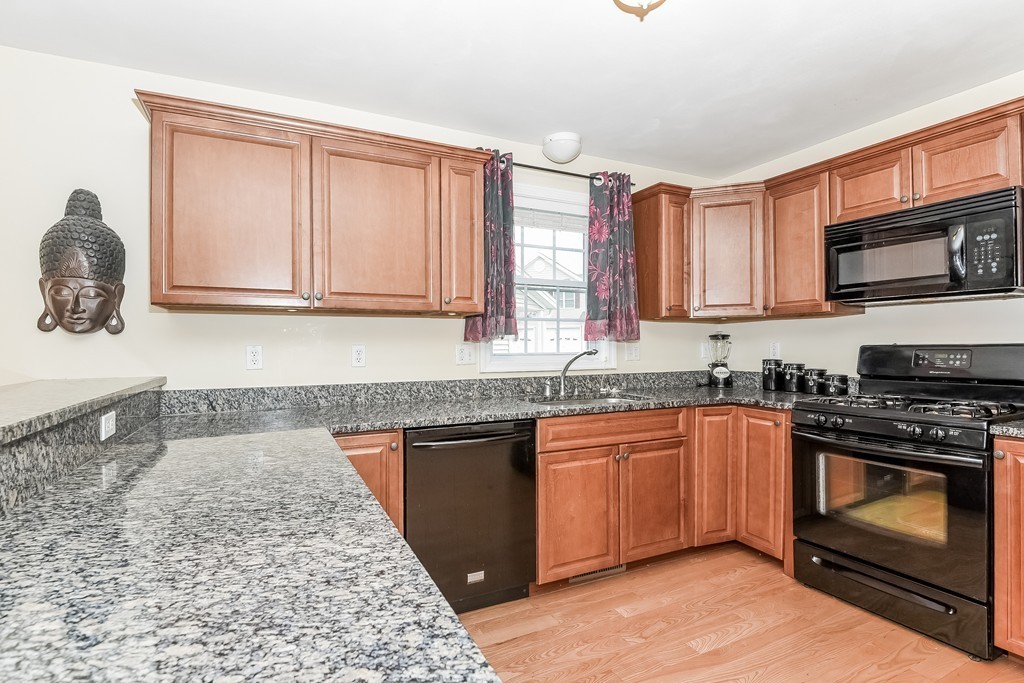 615 Nashua Road, Unit 9 Dracut, MA 01826 - Photo 3 of 30 a kitchen with stainless steel appliances granite countertop a stove sink and cabinets