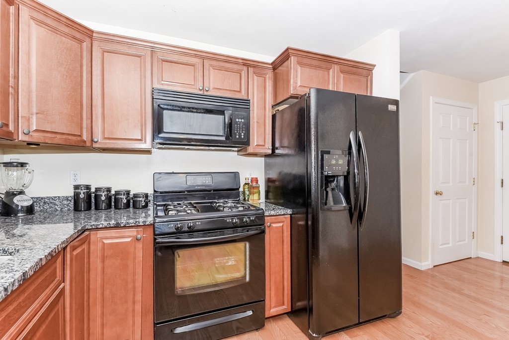 615 Nashua Road, Unit 9 Dracut, MA 01826 - Photo 4 of 30 a kitchen with stainless steel appliances granite countertop a refrigerator stove and sink
