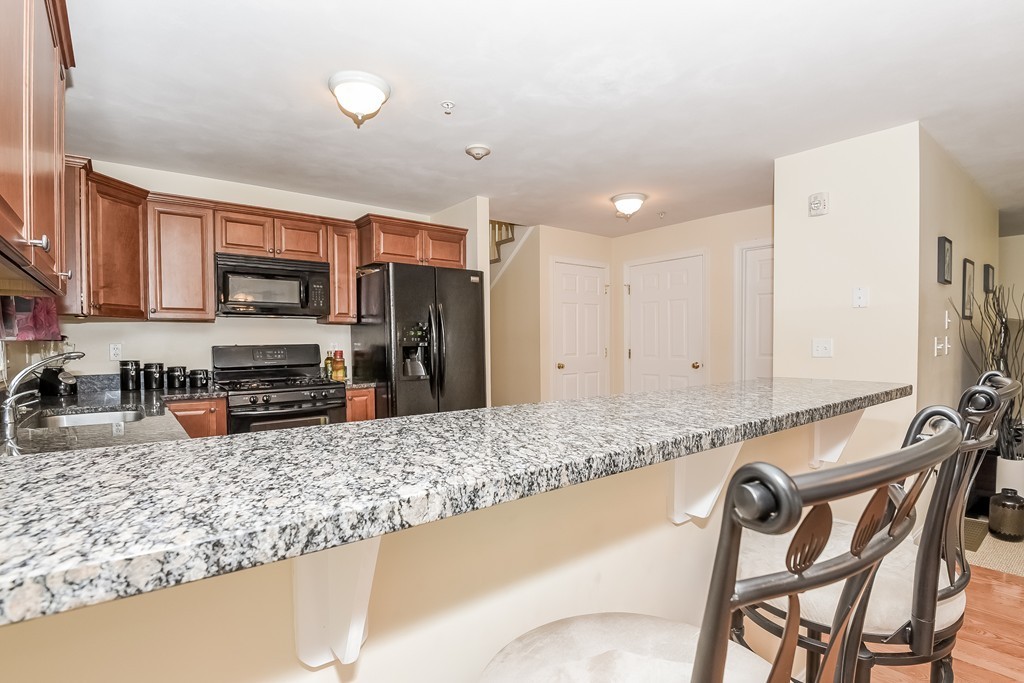615 Nashua Road, Unit 9 Dracut, MA 01826 - Photo 6 of 30 a kitchen with stainless steel appliances granite countertop a stove a sink and a refrigerator