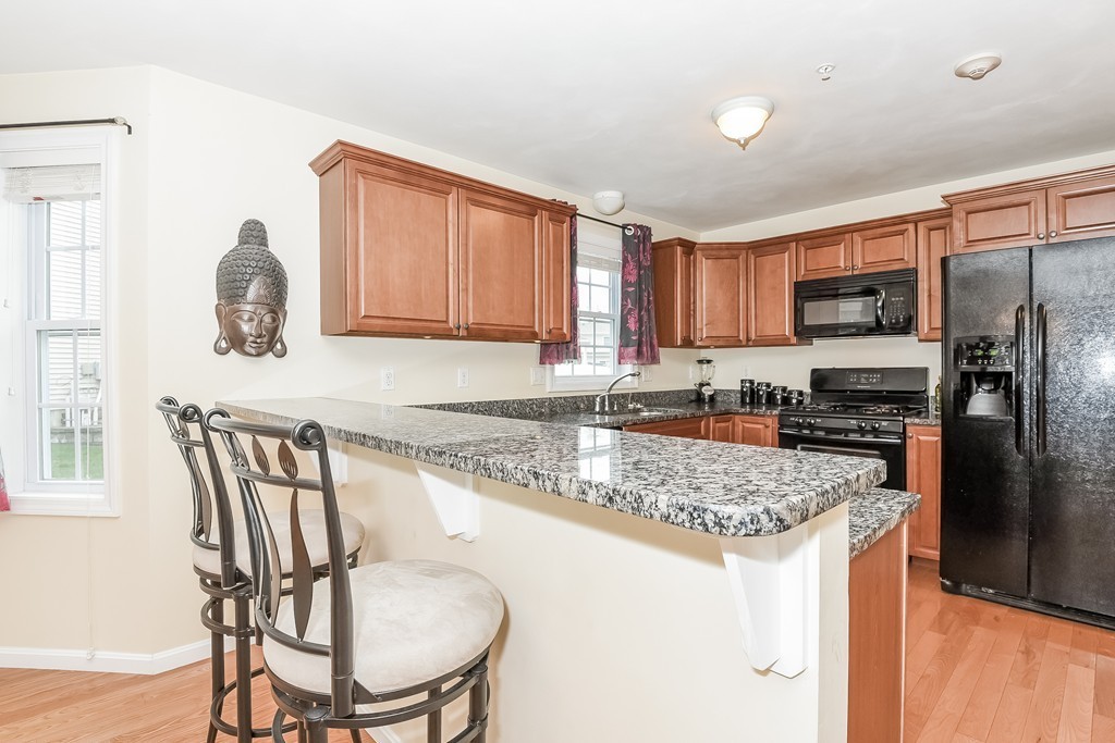 615 Nashua Road, Unit 9 Dracut, MA 01826 - Photo 7 of 30 a kitchen with stainless steel appliances granite countertop a stove a sink a microwave a refrigerator and a refrigerator