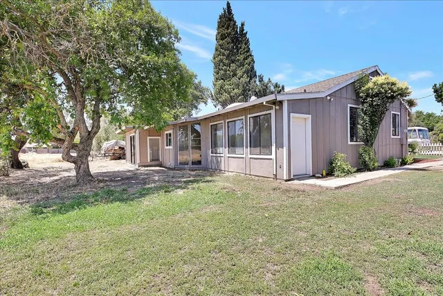 a view of a house with backyard and a tree