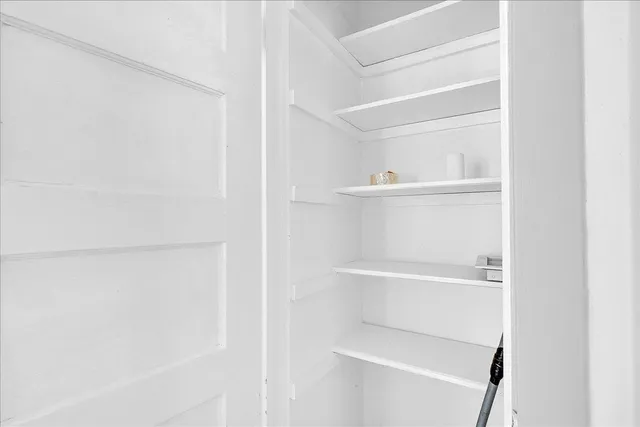 a view of a barn house next to a yard with wooden fence