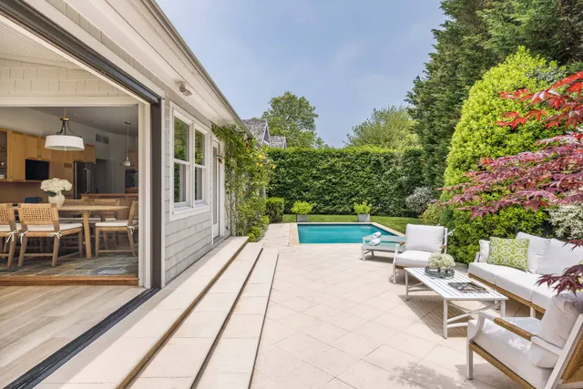 a view of a patio with a dining table and chairs with wooden floor and fence