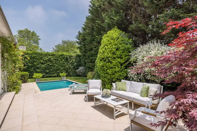 a view of backyard with outdoor seating and trees